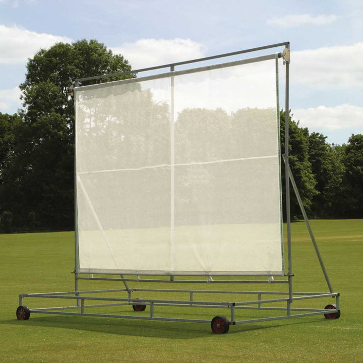 white screen attached to frame in a field with trees in the background
