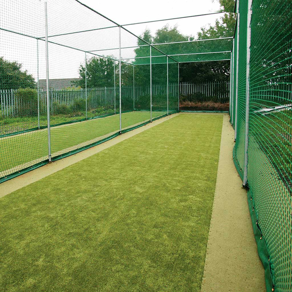 small cricket playing field surrounded by netting 