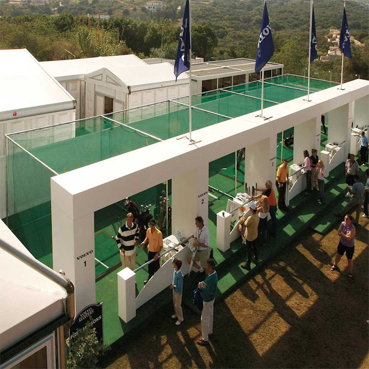 five galvanised frames covers with green netting in place at a Volvo exhibition range with customers viewing them