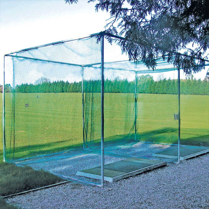 galvanised frame covered with green netting standing on gravel beside an outdoor grass field