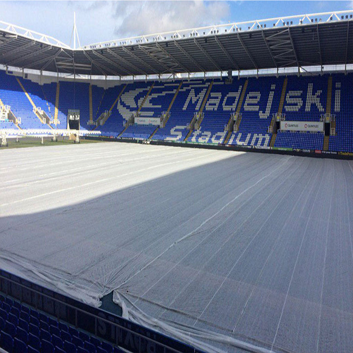 germination sheet laid out on a stadium floor surrounded by blue seats that say MADEJSKI STADIUM