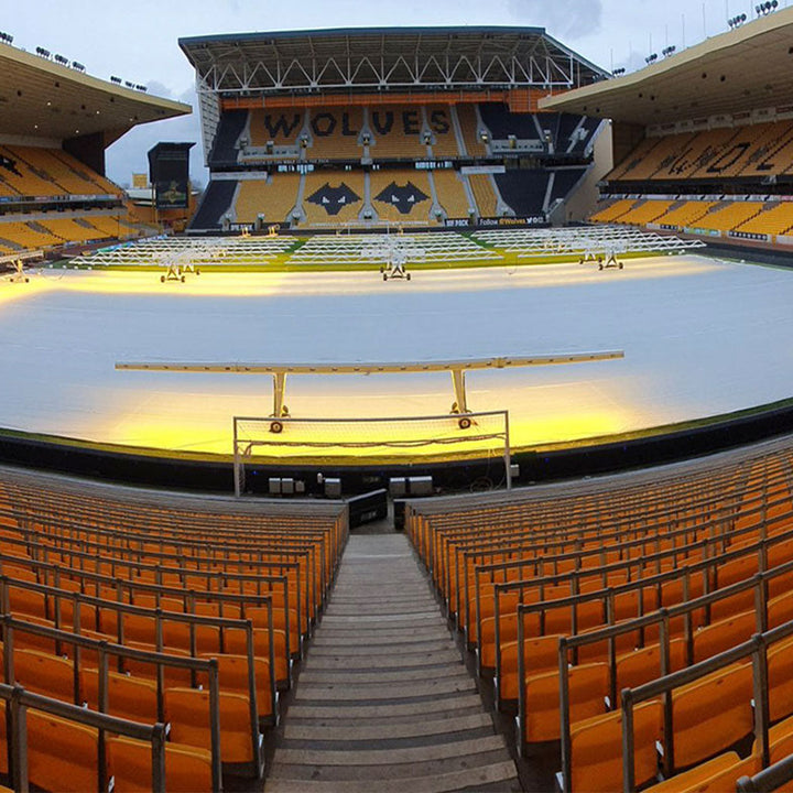economy germination sheet in place over a stadium floor. Orange seats surround the stadium and "WOLVES" is written on them