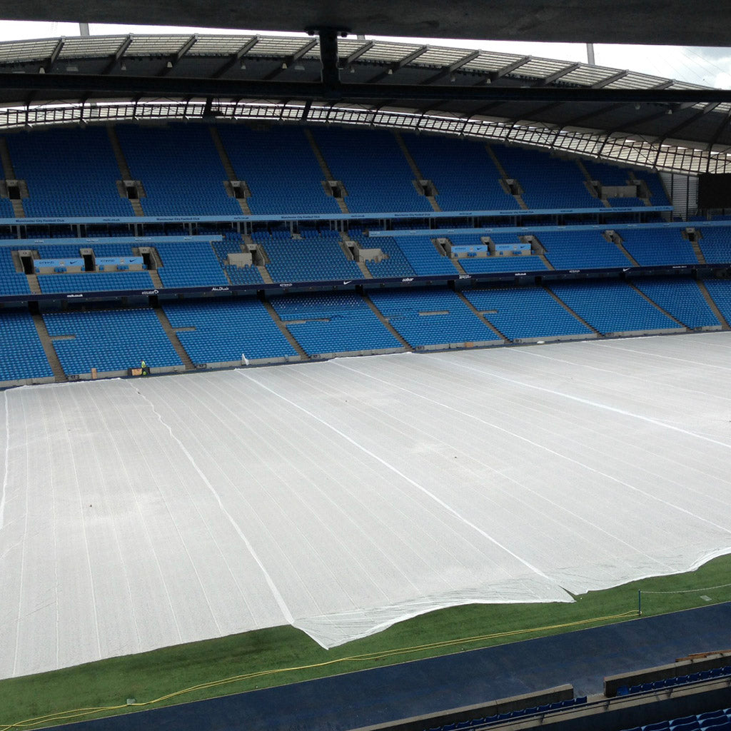 germination sheet laid out on a stadium floor surrounded by blue seats.