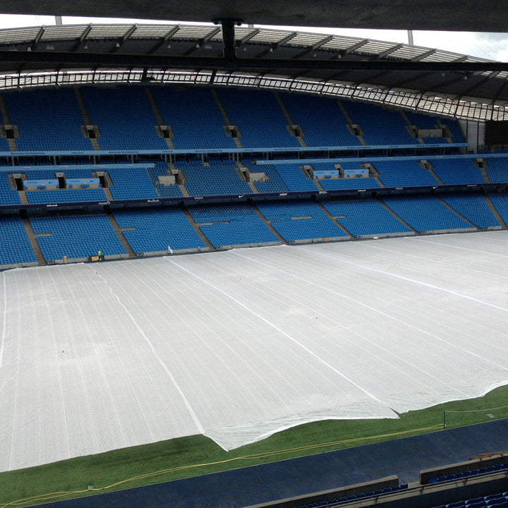 germination sheet laid out on a stadium floor surrounded by blue seats.