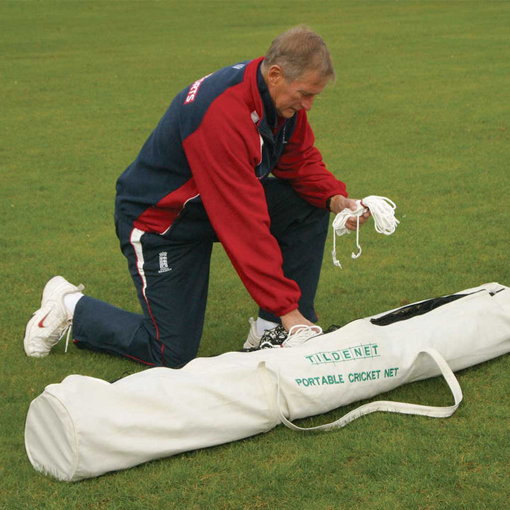 man opening the bag containing a portable cricket net