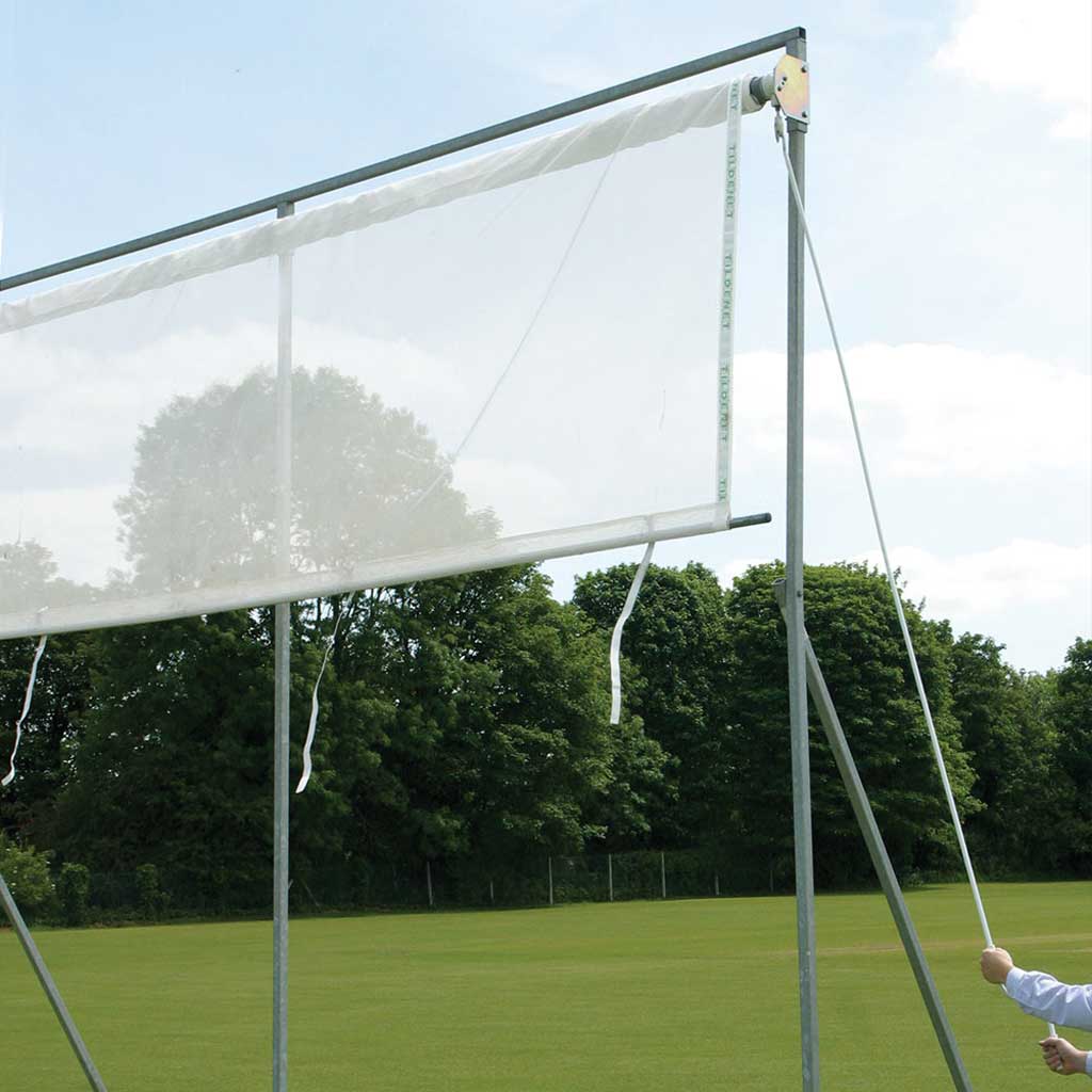 rollable, white screen attached to a frame in a field with trees in the background.