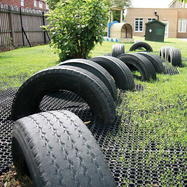 half-tires on Rubber Grass Mat with play equipment in the background