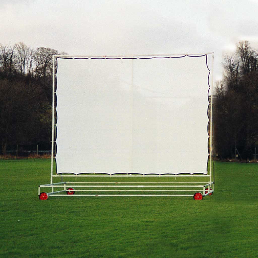 White screen with dark edges attached to a frame with wheels, in a field with trees in the background. 